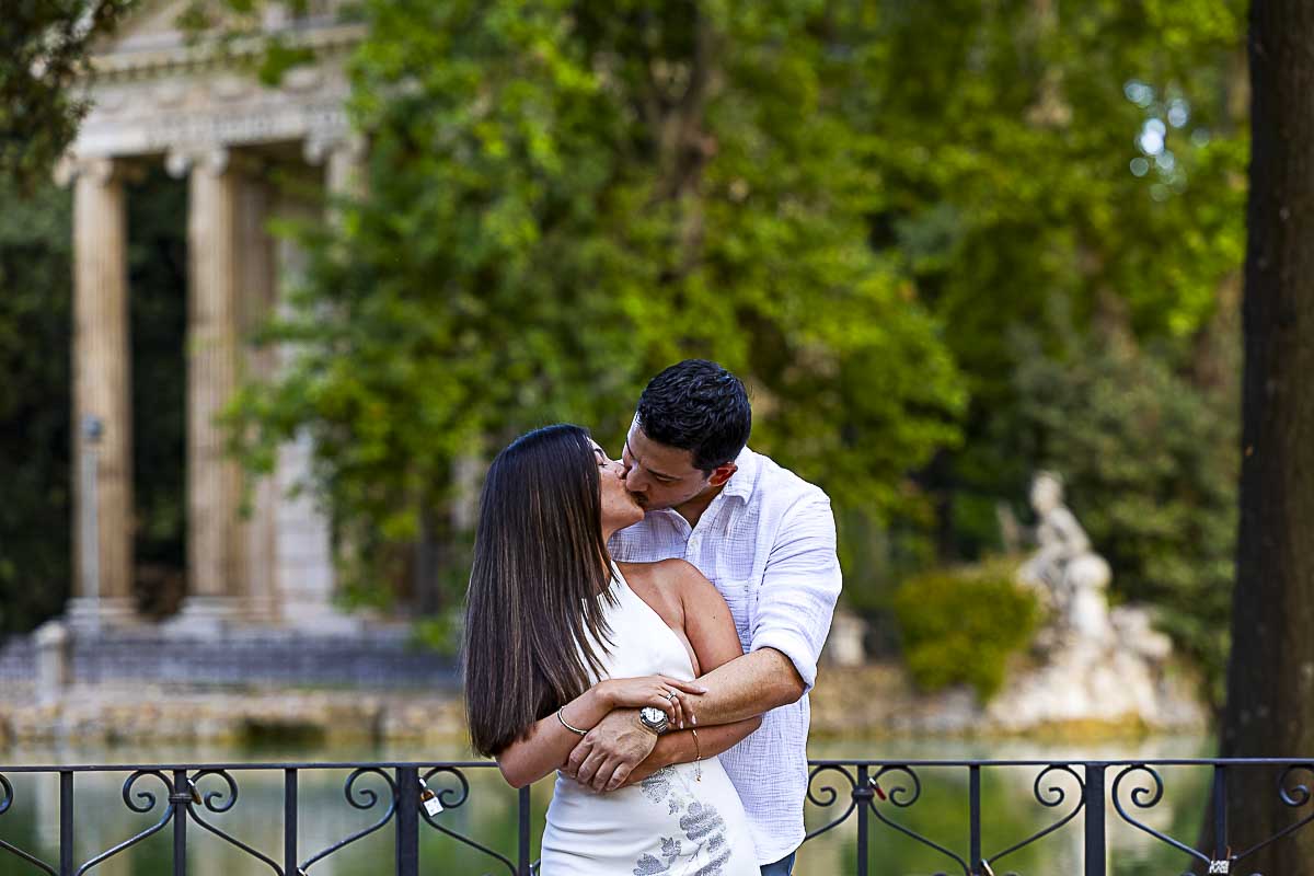 Close up snapshot of them together by the lake with the temple in the background taking a Rome photoshoot together