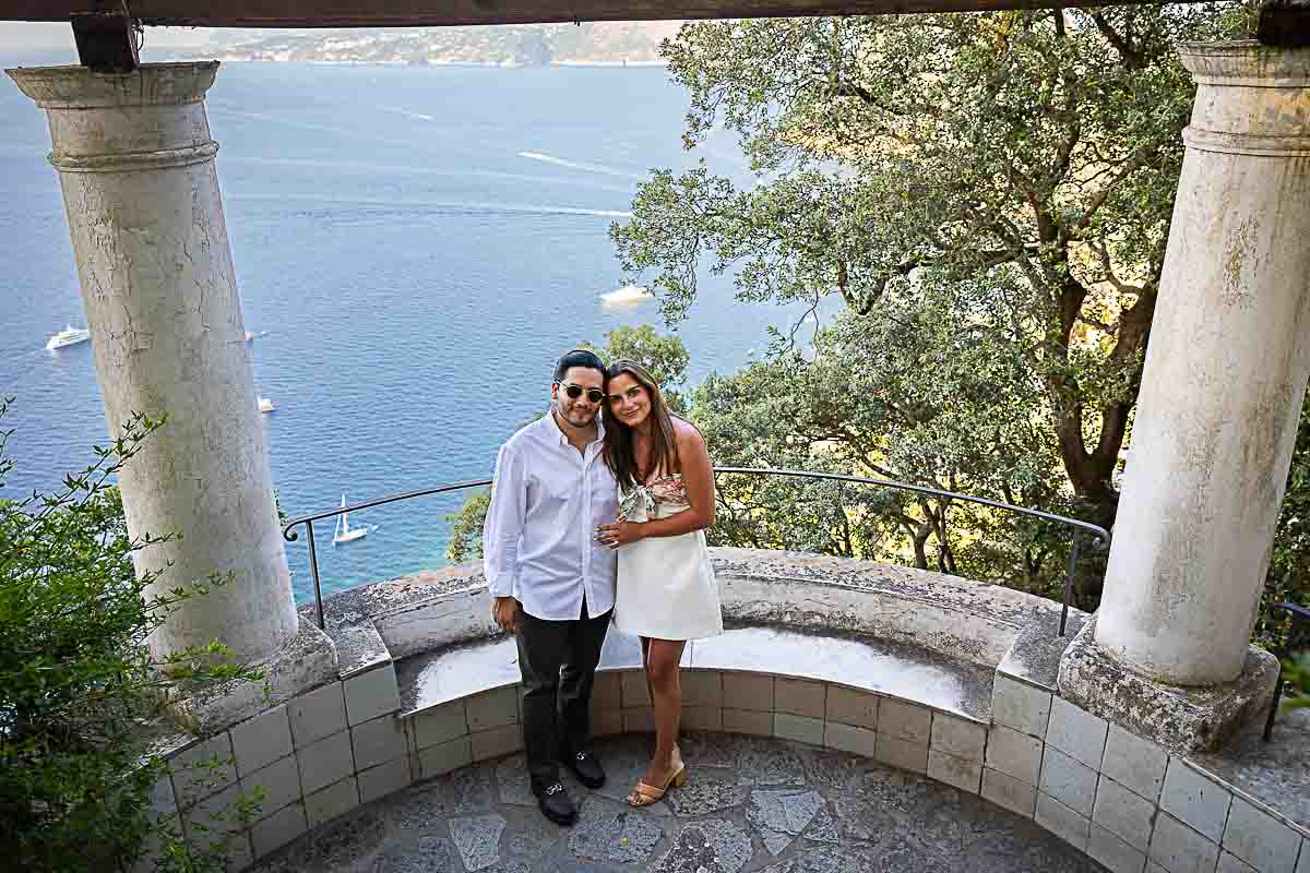 Posed picture photo of newly engaged standing before the seaside town view