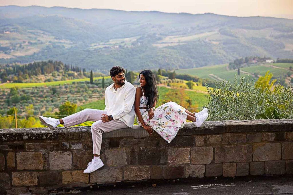 Sitting down on a ledge taking engagement photos during a photoshoot in Italy