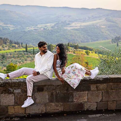 Sitting down on a ledge taking engagement photos during a photoshoot in Italy