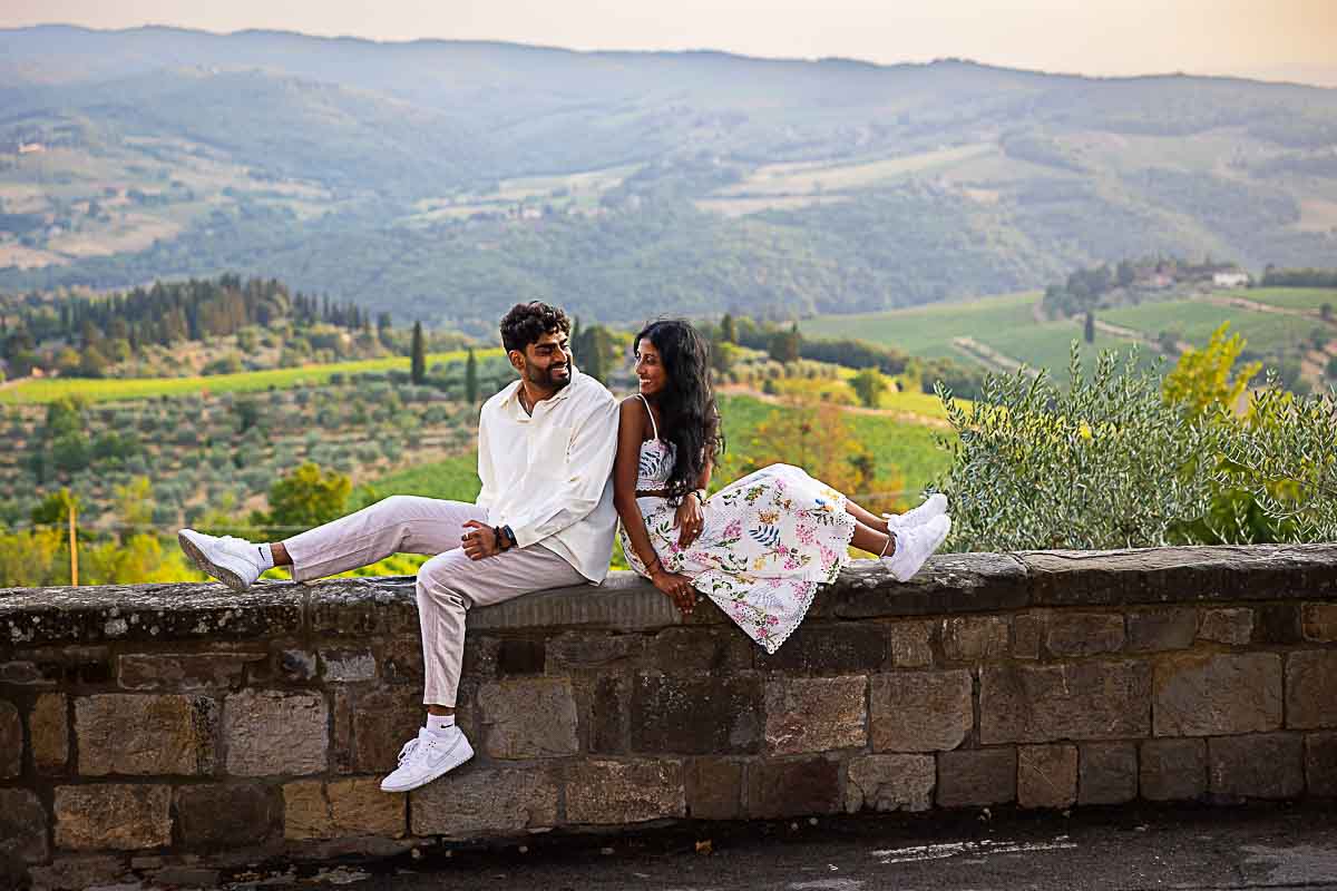 Sitting down on a ledge taking engagement photos during a photoshoot Italy