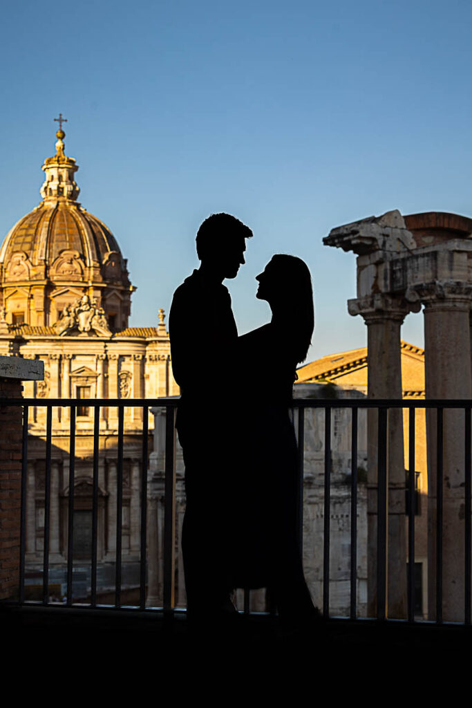 Silhouette image of a couple looking at each other during a photoshoot in Rome over ancient ruins