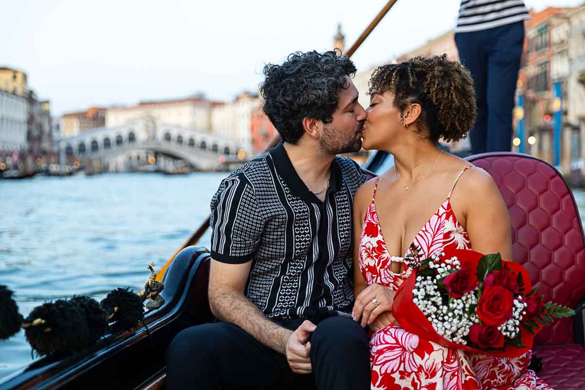 Kissing with the Rialto bridge in the background in Italy