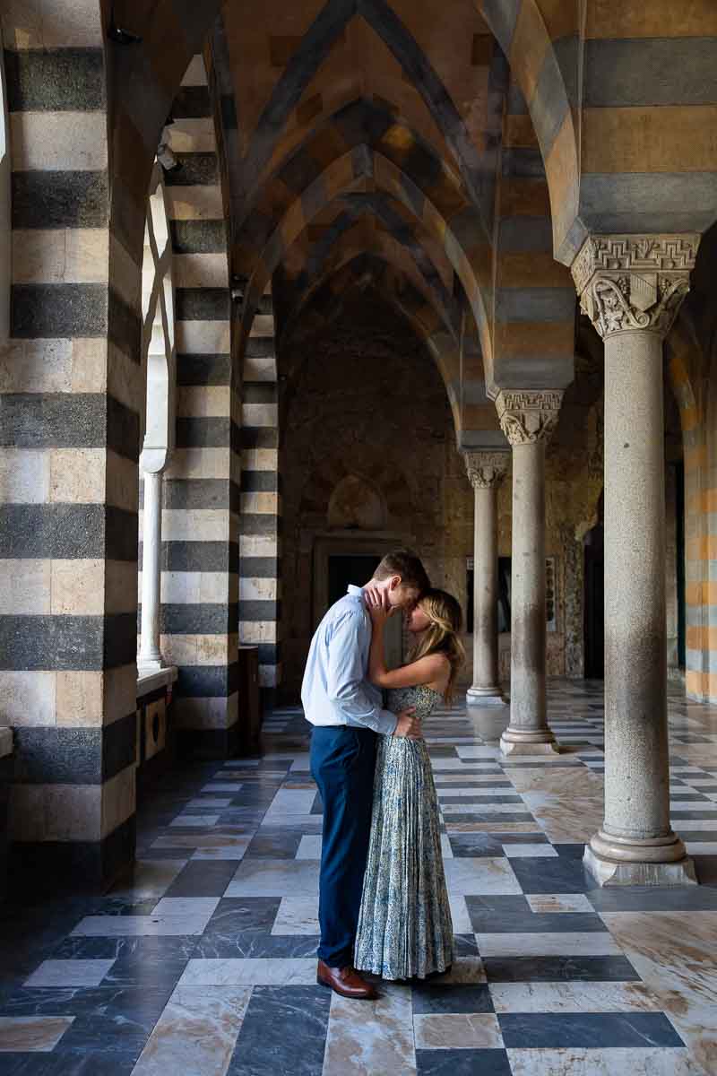 Photo session on top of the Duomo underneath the pillars with the typical architecture. Italian photography session with engagement photos taken in Amalfi during a couple photoshoot in Italy