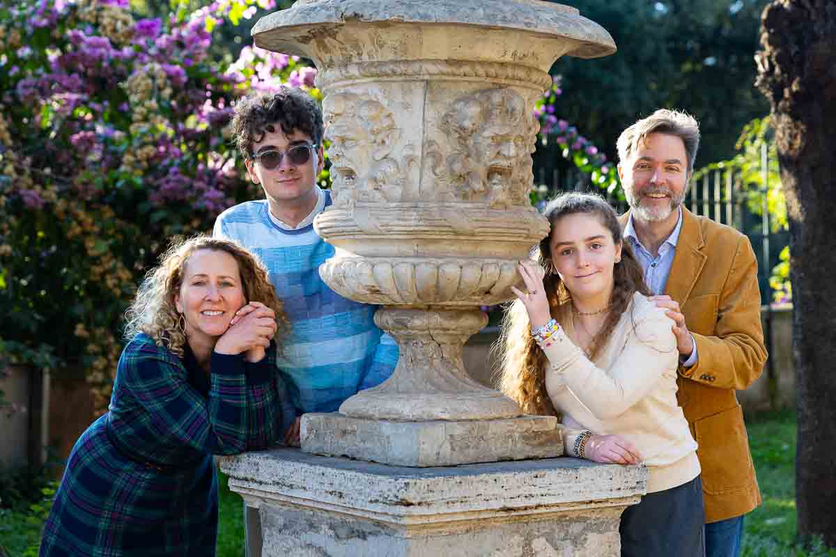 Portrait picture posed next to an ancient roman vase each participant taking on a difference stance for the photography session Italy by a professional photographer. Rome Family Photoshoot in Villa Borghese