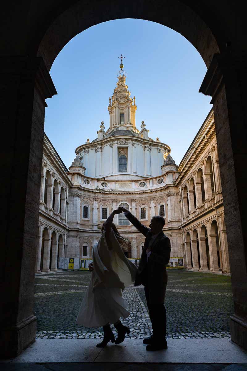 Silhouette photo twirling fiancee in a roman church environment while photography shoot