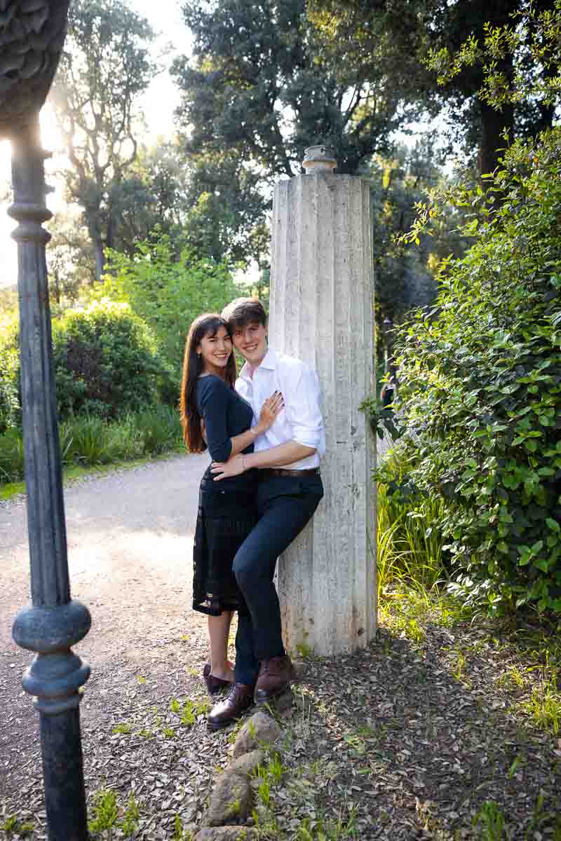 Leaning against a roman column while taking engagement photos in the park during a lifestyle photoshoot