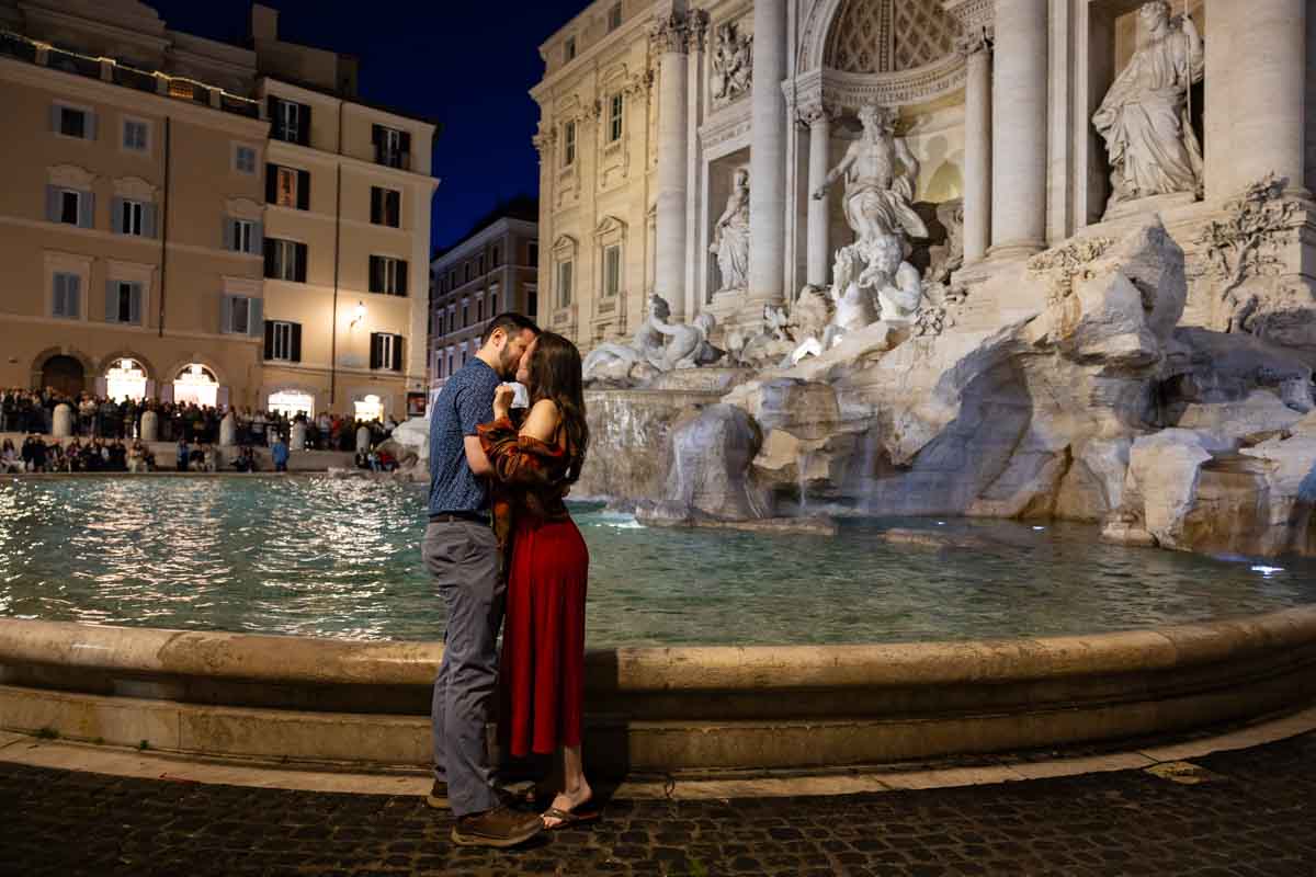 Just engaged kissing by the water fountain edge at night with no one around