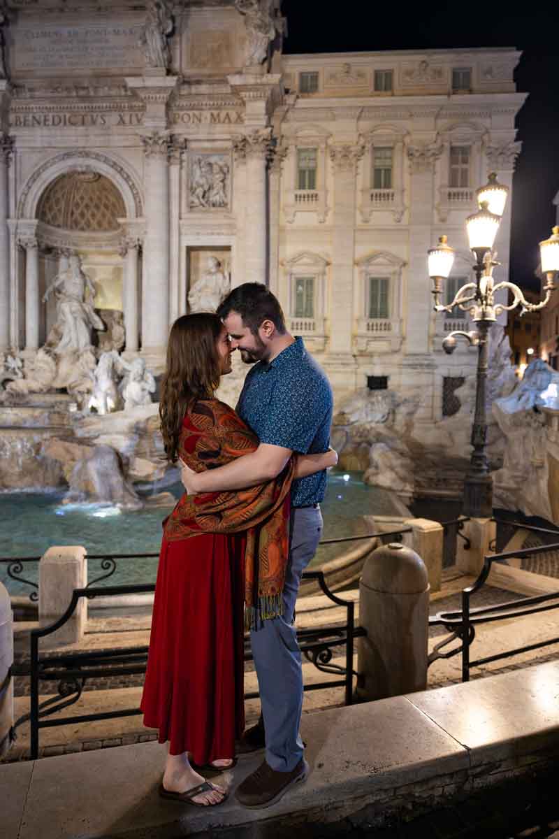 Standing on the ledge facing each other during a nighttime photoshoot as part of in love in Rome photo session
