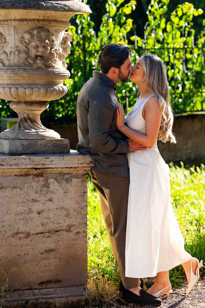 Couple kissing while taking photos together for their engagement in Rome Italy