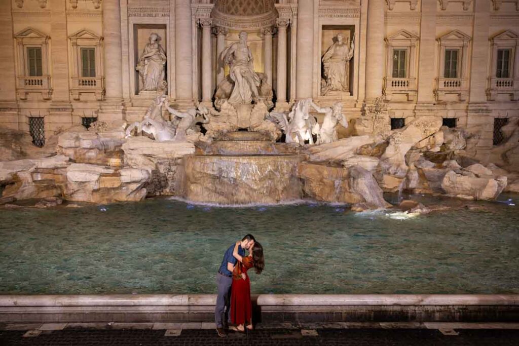 Final picture of the newly engaged couple standing in front of the fountain with no one around