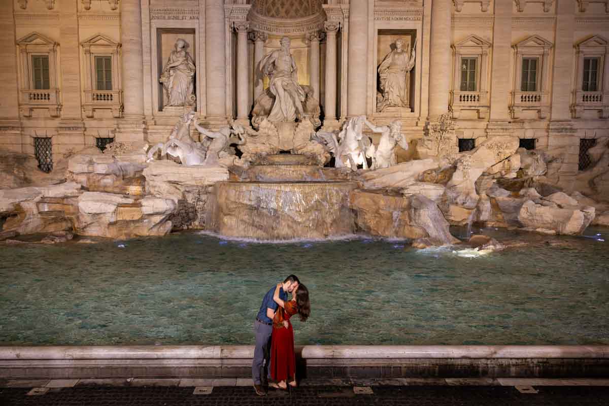 Final picture of the newly engaged couple standing in front of the fountain with no one around