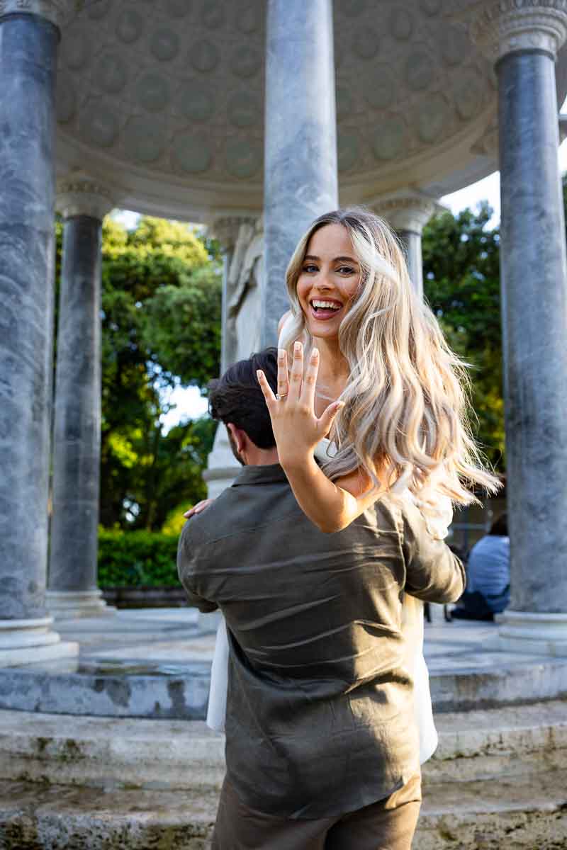Showing the engagement ring to the professional camera while photo shooting at the Diana temple