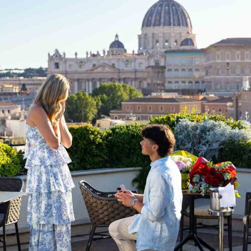 Man proposing to his future wife on an exclusive terrace with a view over the Vatican' Saint Peter's cathedral dome in the far distance with professional photography