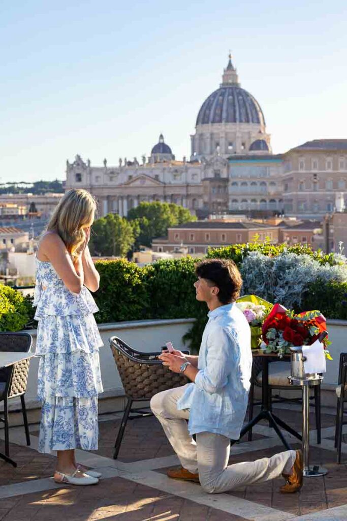 Man proposing to his future wife on an exclusive terrace with a view over the Vatican' Saint Peter's cathedral dome in the far distance with professional photography