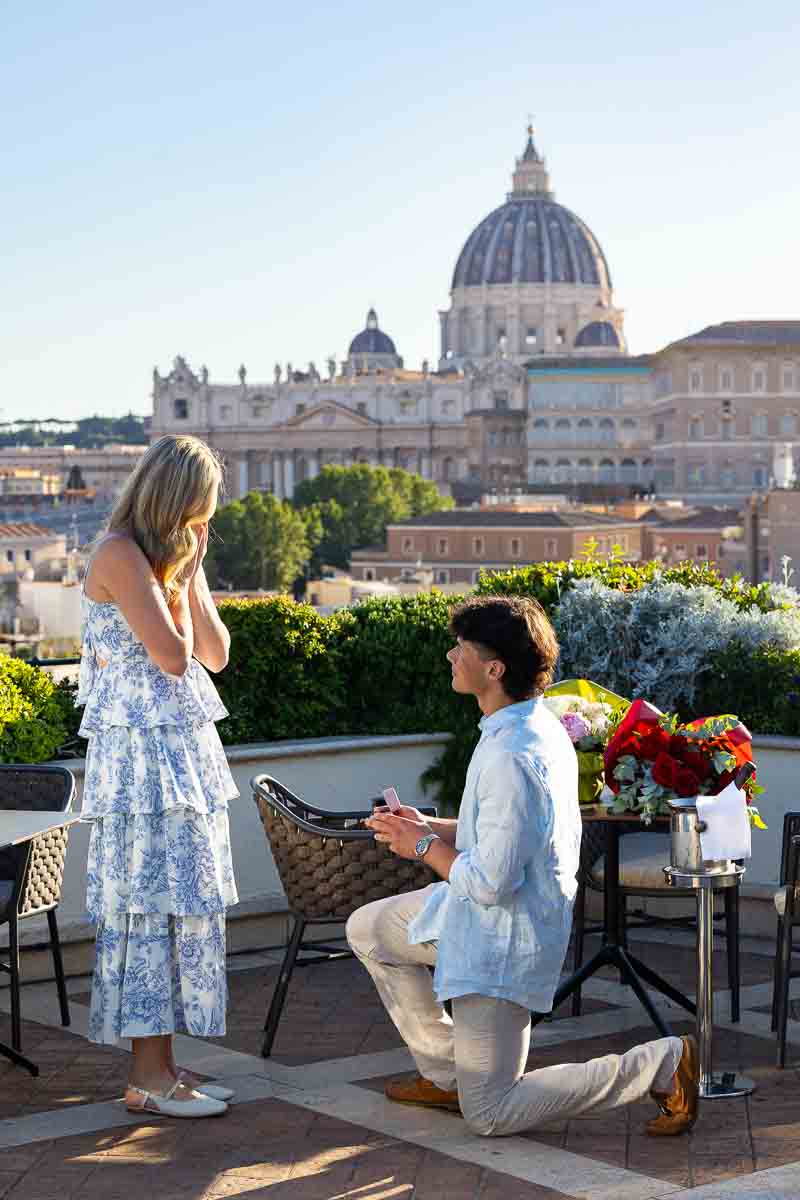 Man proposing to his future wife on an exclusive terrace with a view over the Vatican' Saint Peter's cathedral dome in the far distance with professional photography
