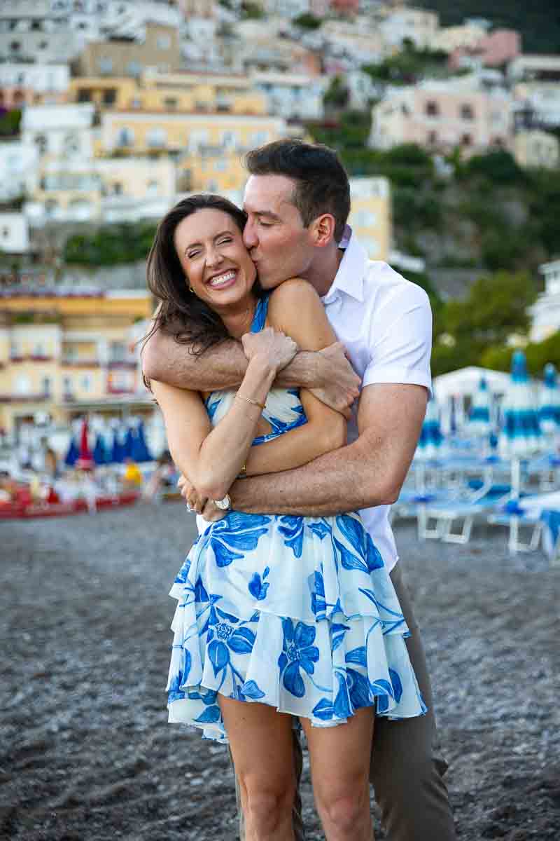 Just engaged by the beach with an enthusiastic embrace smiling and being happy in love during a professional photoshoot