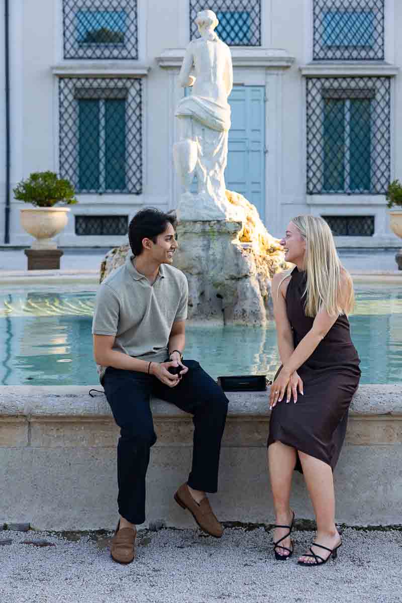 Sitting down next to one another enjoying each other's company while talking about how he proposed here