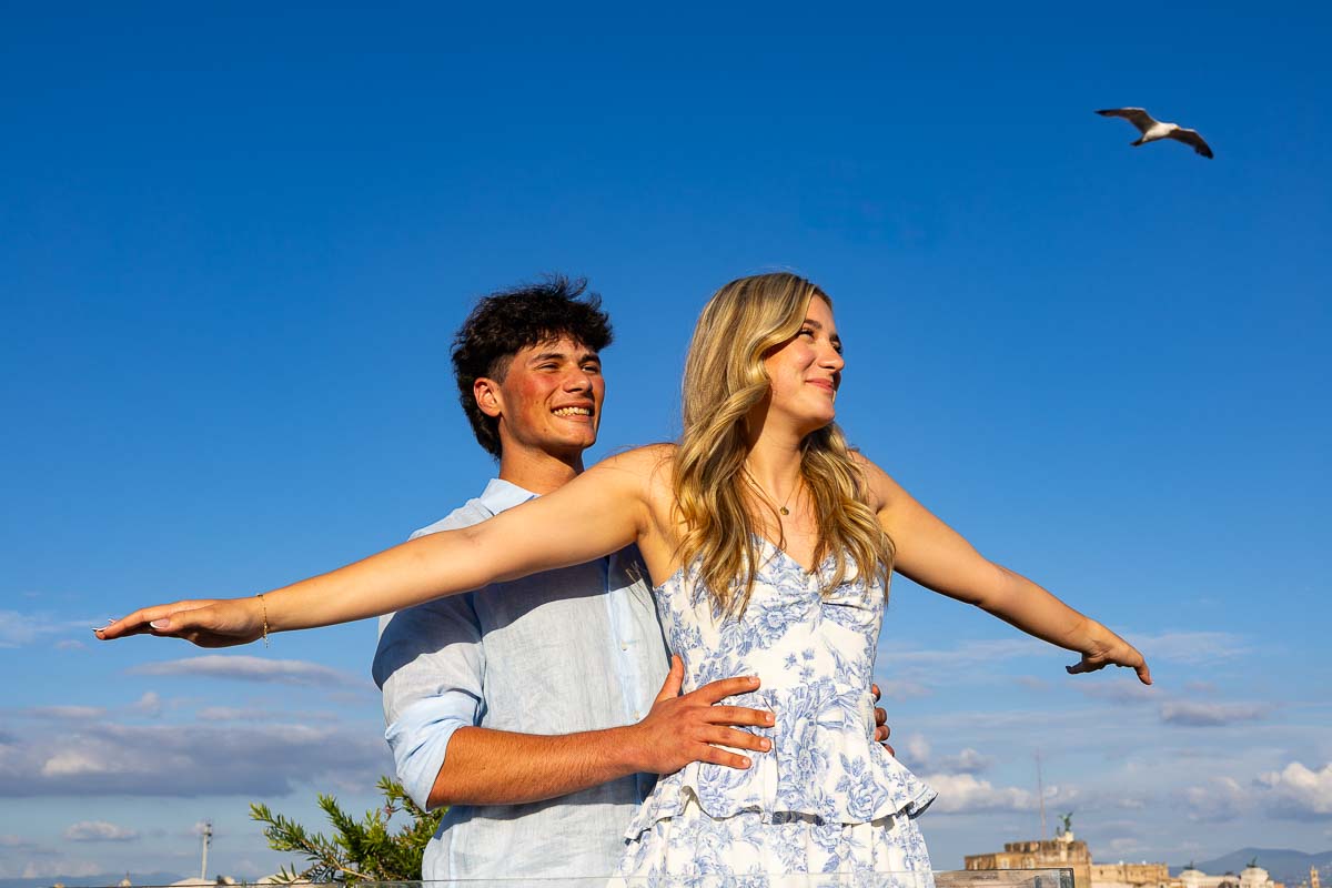 Classic titanic pose with a bird flying up in the air showing the direction fun and playful photography session