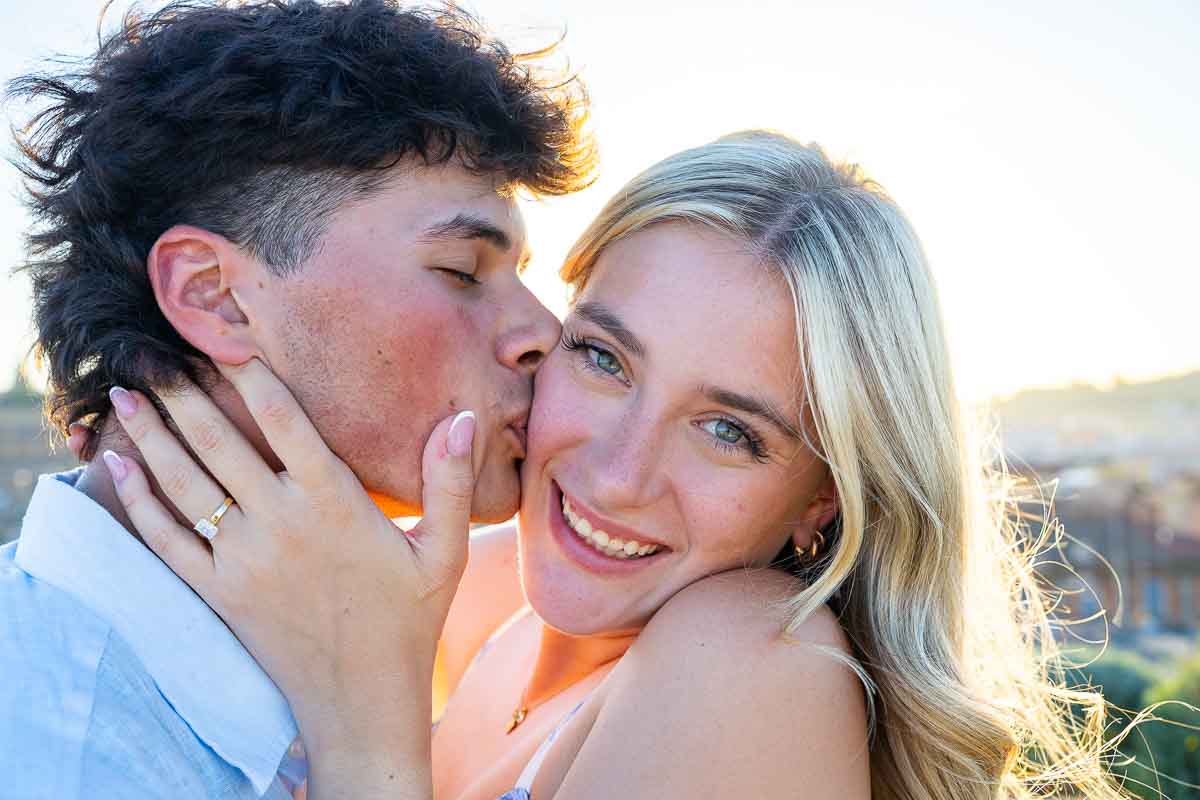 Posed against the light for a nice picture of a kiss in beautiful golden light with lots of smiling for the camera photo session