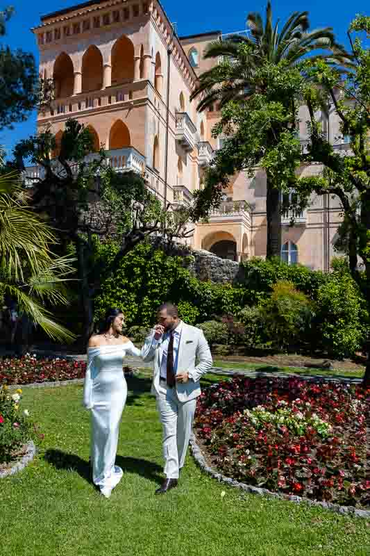 Marital photos walking kissing hand on the beautiful garden estate with lush colors and scenic greenery