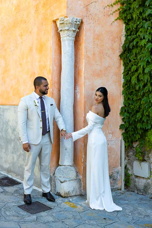 groom and bride portraiture standing next to a column found at a street corner