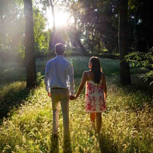 Walking together hand in hand into the setting sun creating long shadows