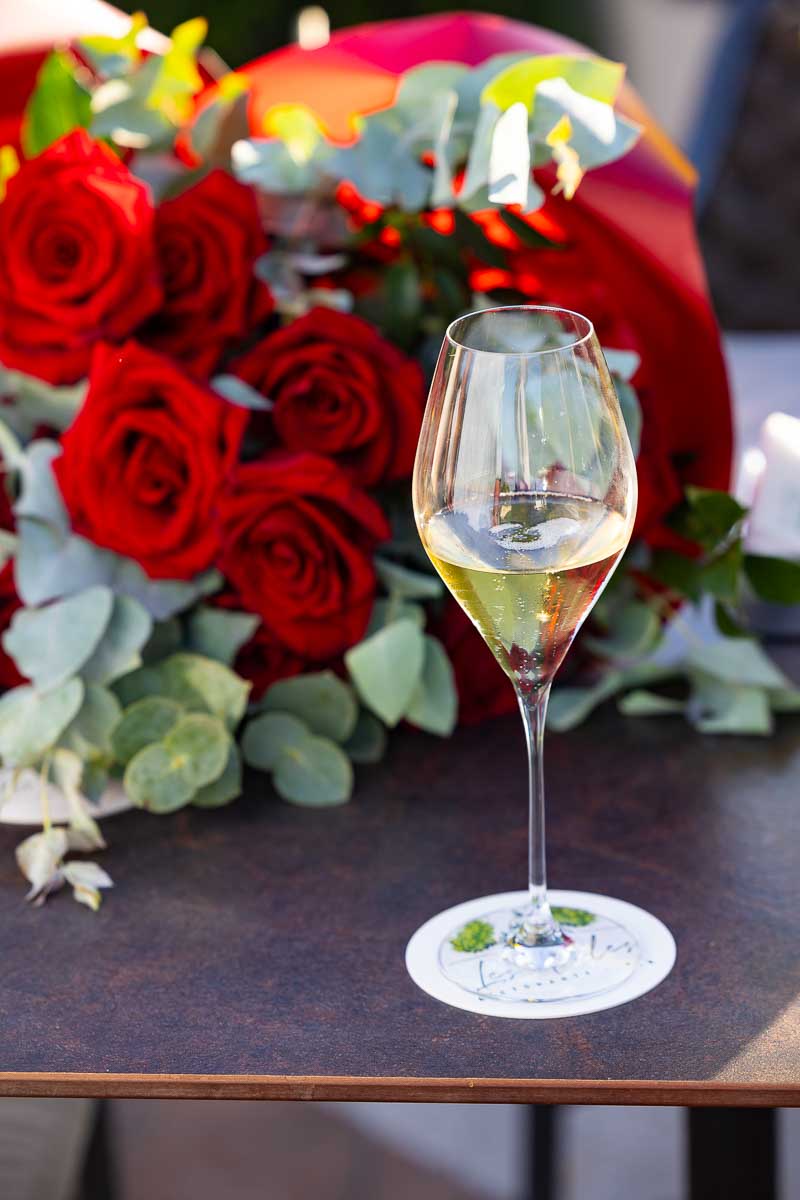 Italian prosecco wine glass photographed against red roses