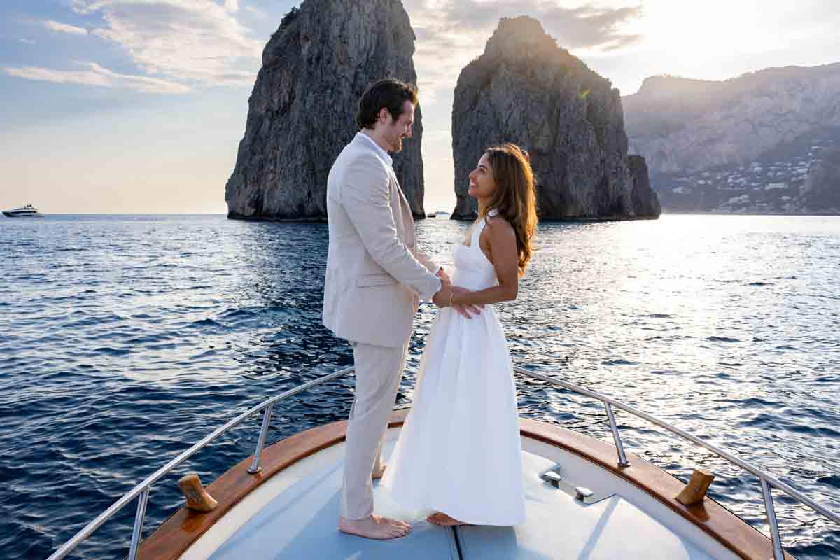 Standing next to one another during the proposing moment in front of one of the most iconic island images