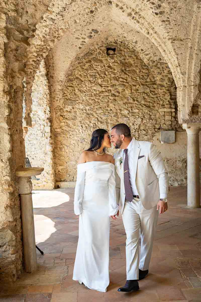 Kissing while walking under ancient portico in the shade of sunlight