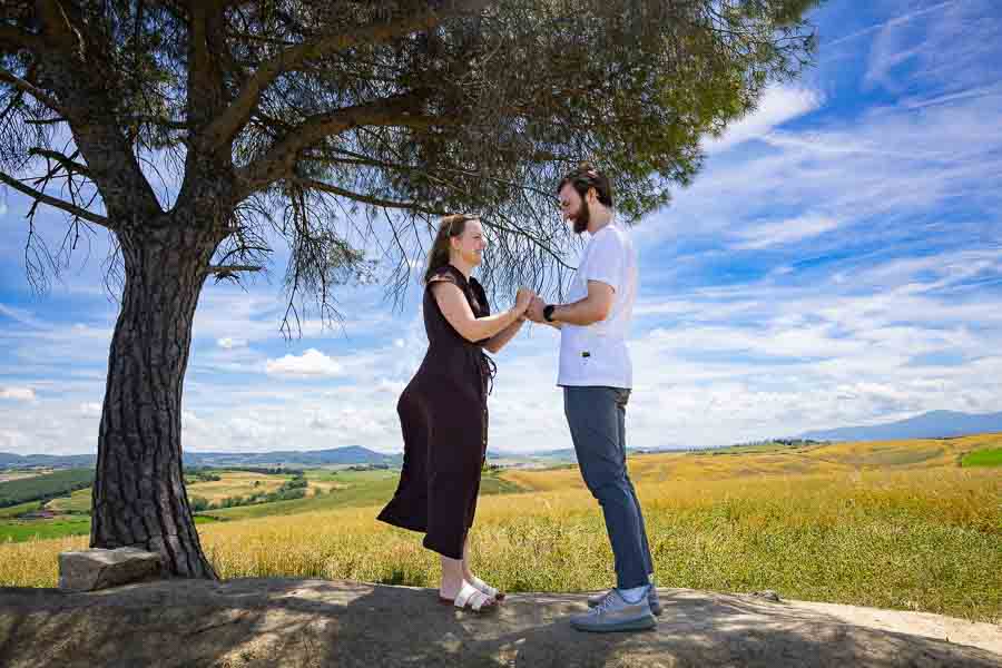 Standing up holding hands still under a tree taking lifestyle photography 