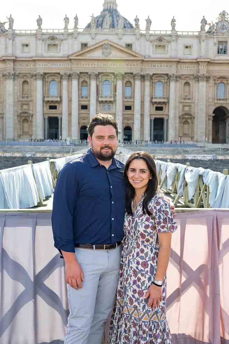 Couple standing before the st peter cathedral close to one another taking photos together. Eternal city. Italy