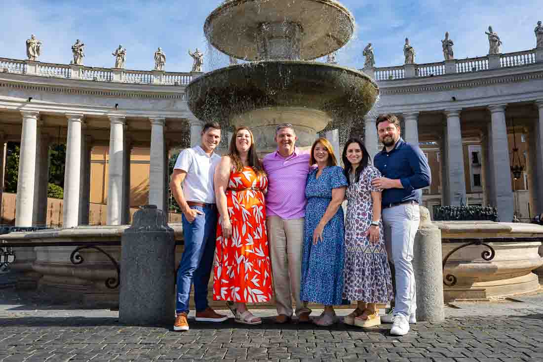 Whole group posed again by one of the water fountains found in square of Saint Peter during a photography session as vacation and travel photos