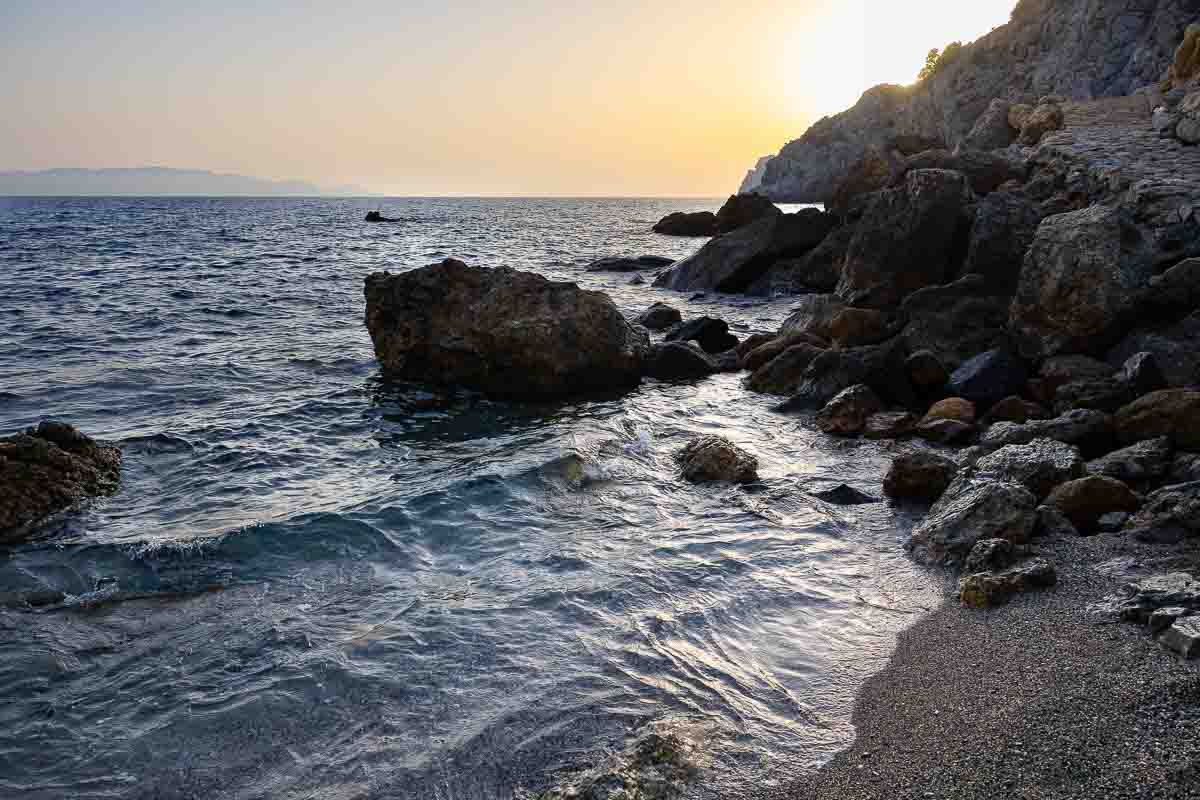 Coastal landscape photograph featuring the rocky shoreline, clear Mediterranean water, and peaceful atmosphere in southern Tuscany. Seascape photography