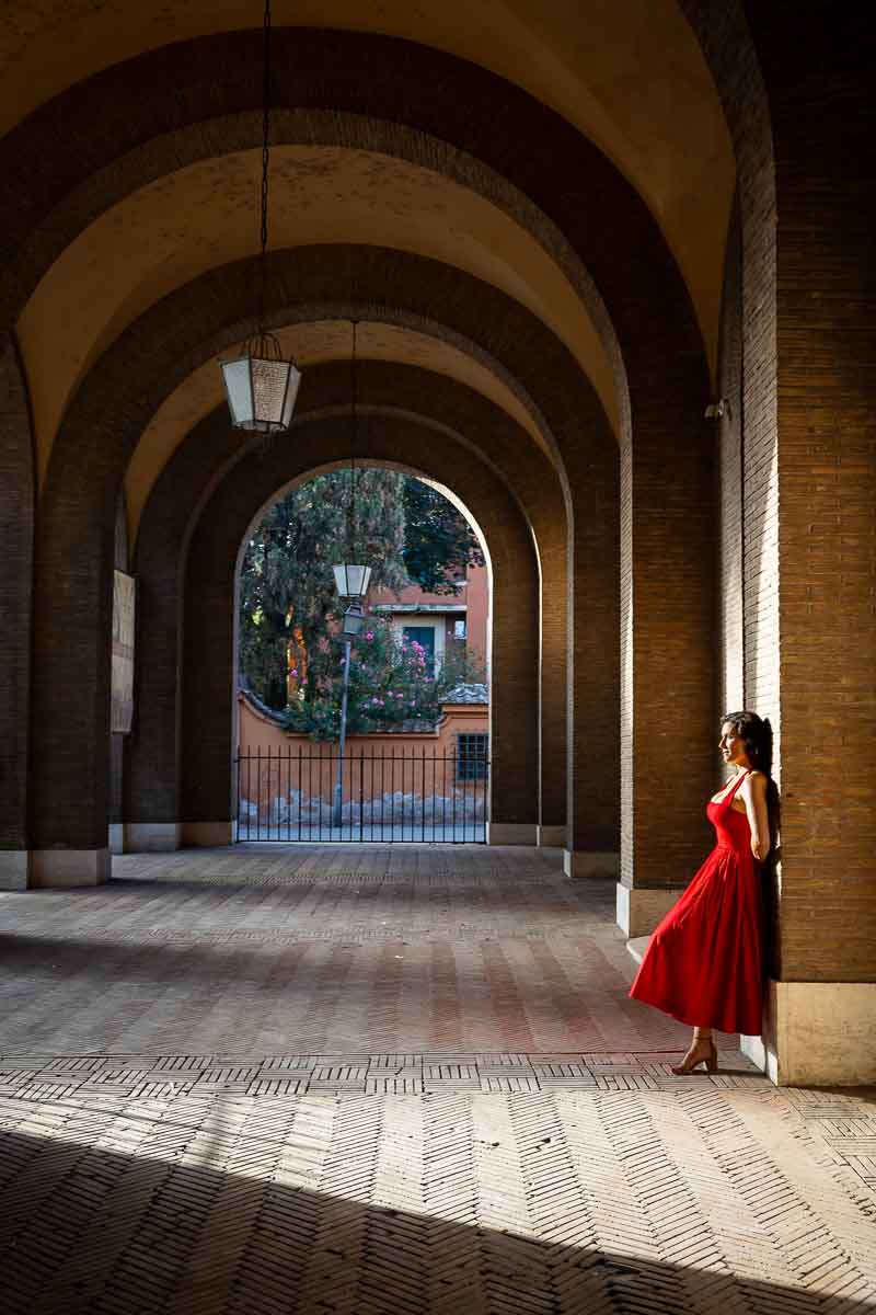 Editorial-style portrait captured beneath the elegant portico of Santa Sabina, using architectural lines, soft morning shadows, and geometric shapes to create a refined travel image.