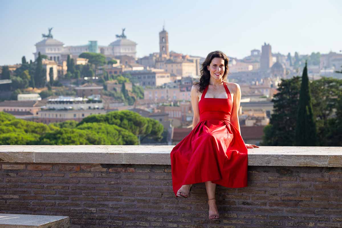 Environmental portrait of a woman sitting peacefully with panoramic views across historic rooftops and landmarks, photographed during a quiet morning city exploration.