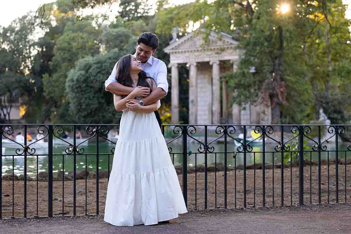 Posed snapshot of a couple in love by the lake holding each other during a sunset photoshoot
