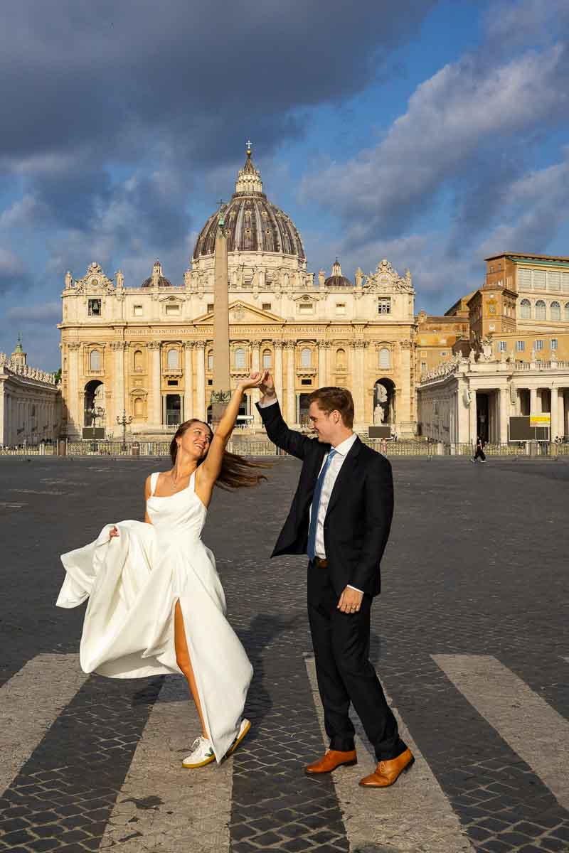 Playful spinning moment on a cobblestone street, frozen in a lively frame that captures movement and affection during the morning session