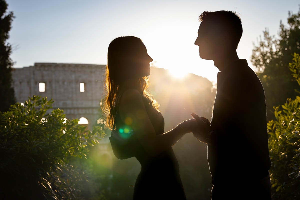 Silhouette photoshoot artistic photo of them holding hands against sun setting light during a photo session in Italy