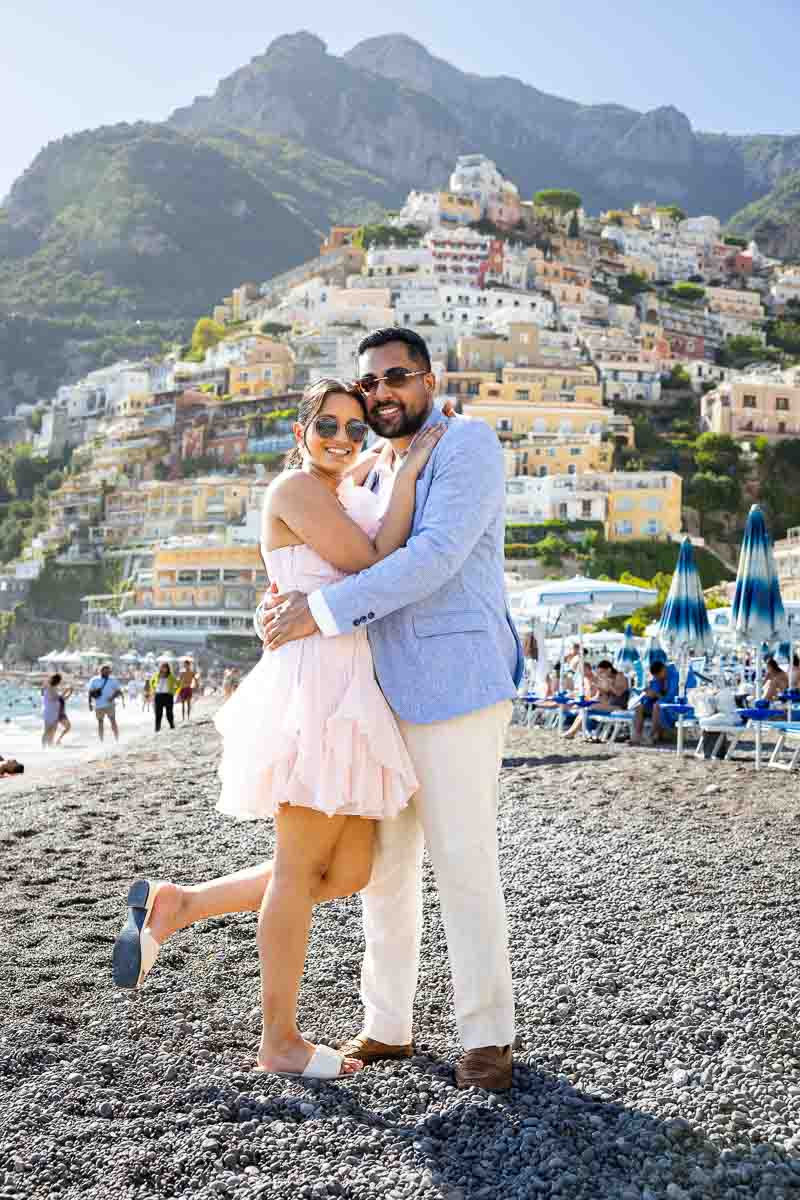 Seaside snapshot showcasing a couple interacting with the cascading pastel houses behind them.